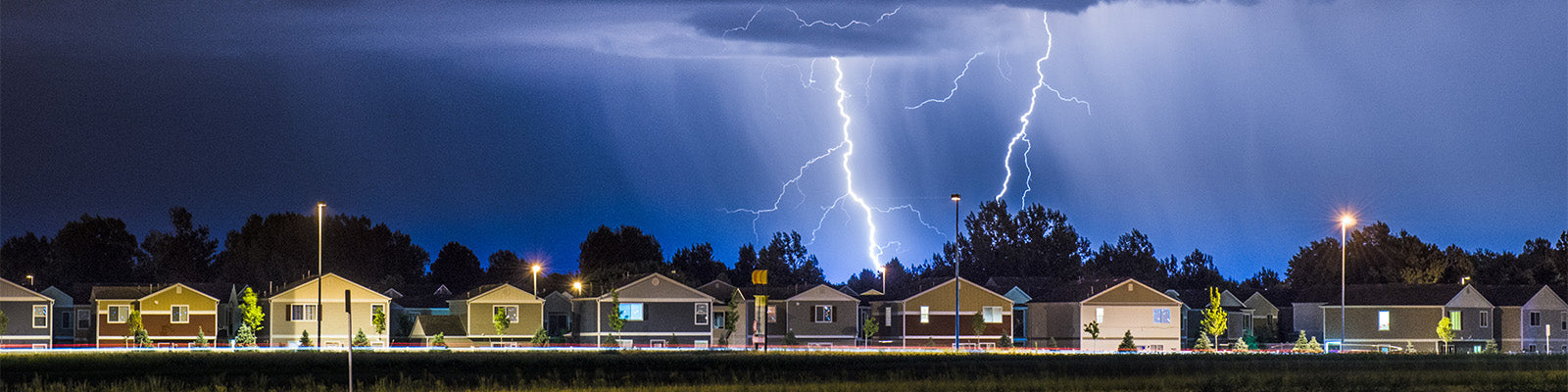 well-lit-house-in-suburb-electrical-storm-overhead-big-crop
